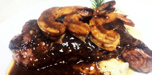 Barracudas delicious juicy steak dinner resting on mashed potatoes and gravy, topped with jumbo shrimp, Locust Point