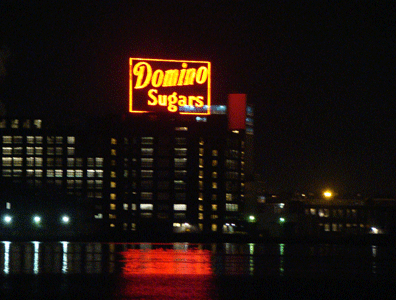 Famous Domino Sugars sign reflecting on the Harbor at night in Locust Point Baltimore MD