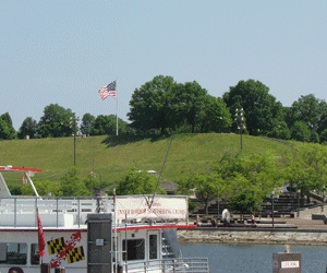 Image of Federal Hill Park with US flag proudly flying taken from Harborplace Waterfront Promenade Baltimore MD
