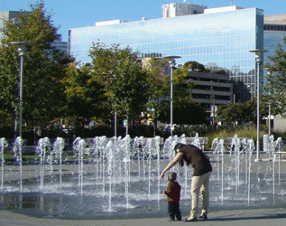 Image of mother and child enjoying the fountains at West Shore Park, Inner Harbor, Baltimore MD