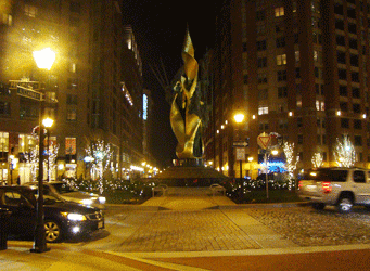 Vibrant night view of Katyn Memorial Circle with golden hues, President & Aliceanna Streets Harbor East Baltimore MD