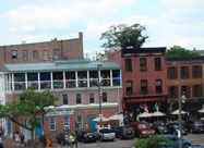 Image of Woody's Rum Bar & Island Grill with scenic rooftop view of the harbor, next to Slainte Irish Pub & Restaurant & Kooper's Tavern, on the waterfront at the corner of historic Belgian block paved Thames Street & Broadway in Fell's Point, Baltimore, MD