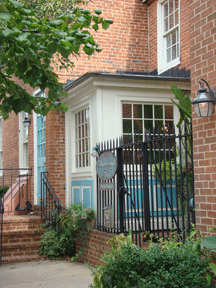 Featured Hotels and Lodging image of an attractive entrance to a neighborhood bed and breakfast with wrought iron fencing, trees and shrubbery in Federal Hill Baltimore MD